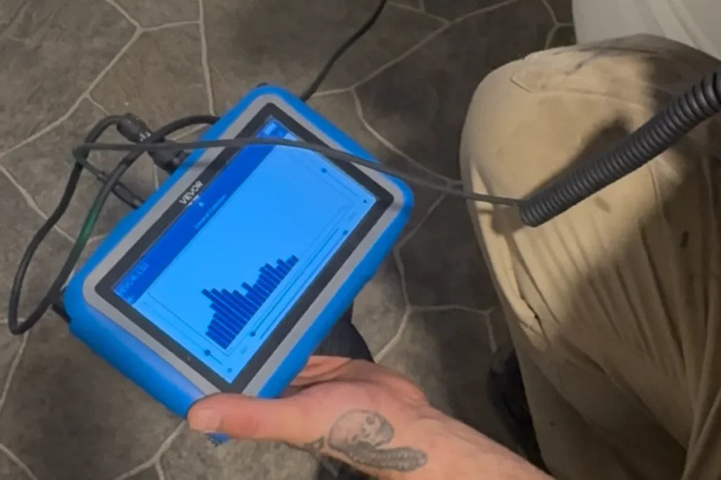 Plumber using electronic leak detection equipment