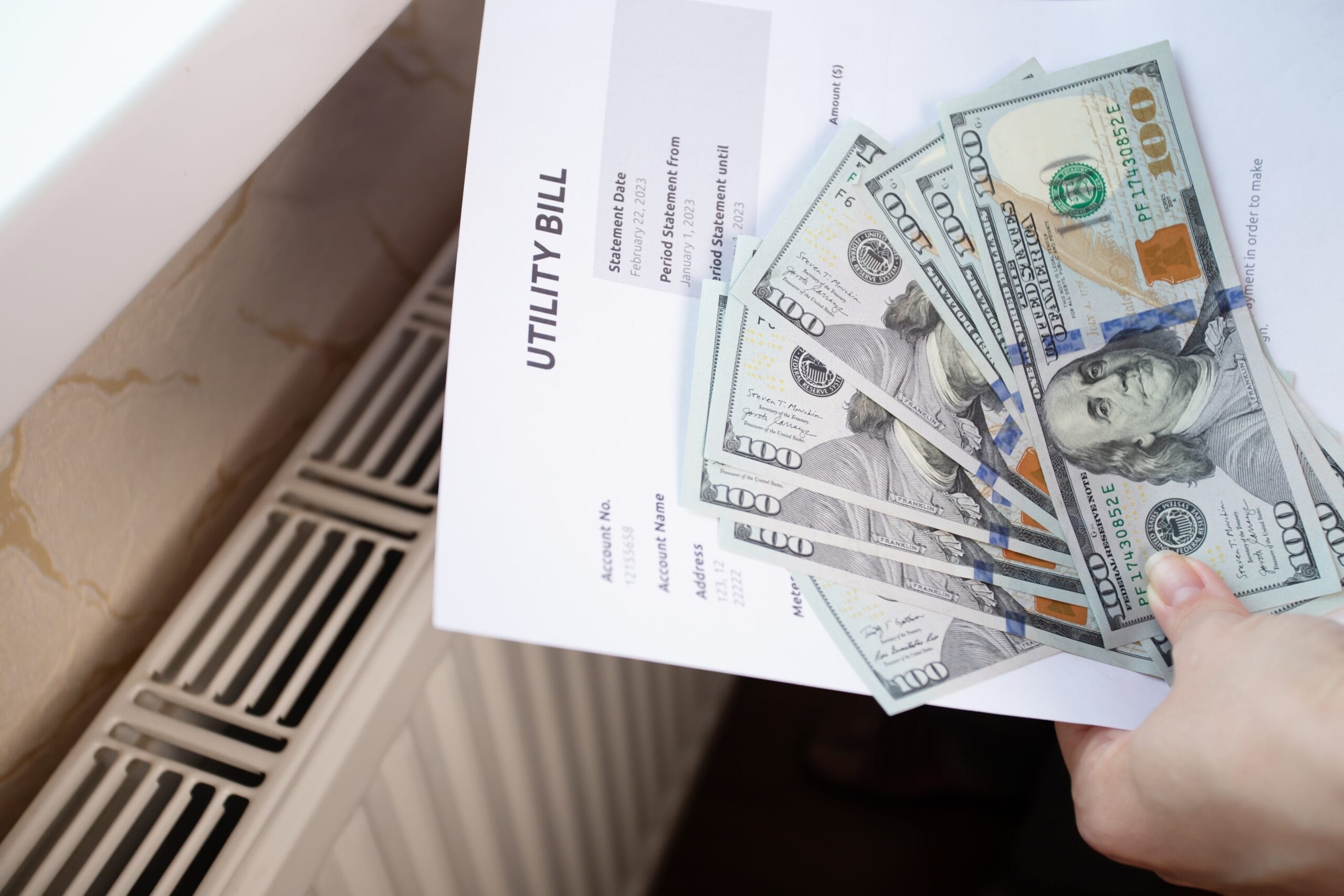 A high utility bill held above a floor drain